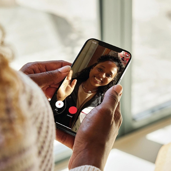 Woman remotely speaking to someone at her front door via the Yale Smart Video Doorbell